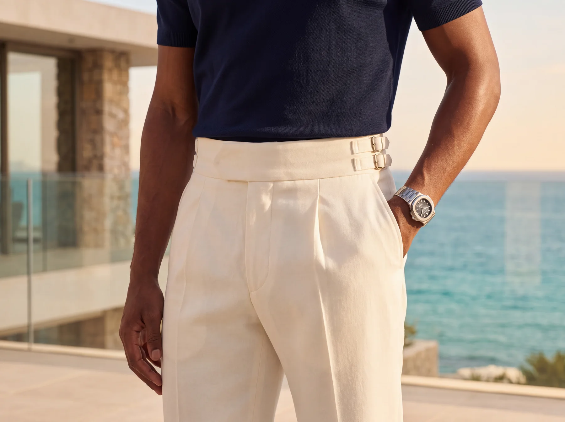 Close view of the ivory Palazzo trouser worn high at the waist with a navy knit polo tucked in.